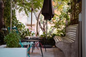 patio con tavolo, sedie e ombrellone di Athens Green Apartments ad Atene