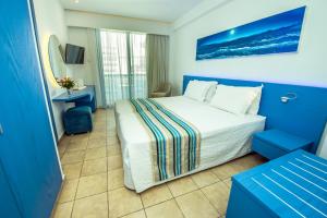 a hotel room with a bed and a television at Anonymous Beach Hotel (Adults 16+) in Ayia Napa