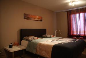 1 dormitorio con cama, mesa y ventana en Vakantie Logies Allo Allo en Poperinge