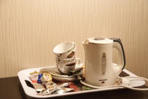 a tray with a tea kettle and cups on a table at Vakantie Logies Allo Allo in Poperinge