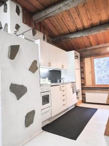 a kitchen with white cabinets and a stove at Riemula cabin in Kuusamo