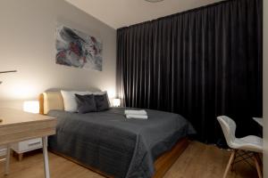 a bedroom with a bed and a desk and a window at Wola Chic Silver Studio in Warsaw