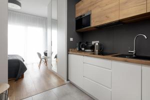 a kitchen with white cabinets and a sink at Wola Chic Silver Studio in Warsaw