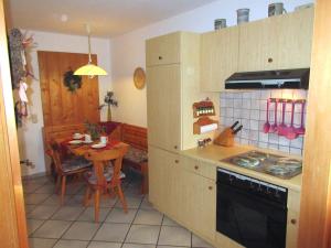 eine kleine Küche mit einem Tisch und einem Herd in der Unterkunft Lohnerhof in Kirchanschöring