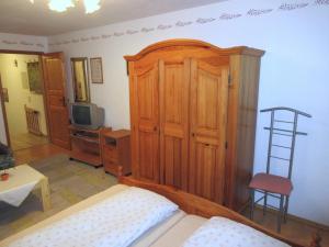 Schlafzimmer mit einem Bett und einem Holzschrank in der Unterkunft Lohnerhof in Kirchanschöring