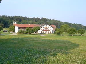 ein großes Haus auf einem Feld mit einem großen Rasenplatz in der Unterkunft Lohnerhof in Kirchanschöring