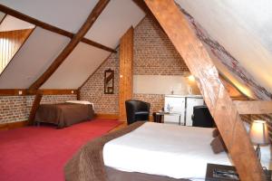 a attic room with a bed and a kitchen at Le Domaine des Cigognes in Ennevelin