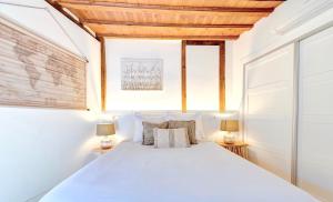 a bedroom with a white bed with two lamps at ~SILVER~ Edificio Singular S.XVIII. Centro in Toledo