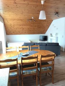 a dining room with a table and a blue couch at Gästehaus-Après-Park in Rust