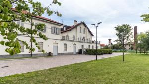 ein großes weißes Haus mit einem Rasenplatz in der Unterkunft Residence Le Querce in Monza