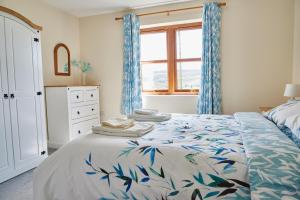 Finest Retreats - Quail's Nest Cottage في Edlingham: غرفة نوم بسرير والستائر زرقاء