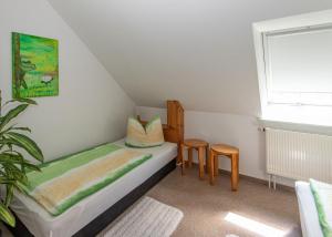 a small bedroom with a bed and two chairs at Gesundheitsoase in Burg