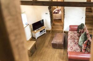 a living room with a couch and a tv at Foxglove - Luxurious Barn Conversion - Blossom Farm in Johnston