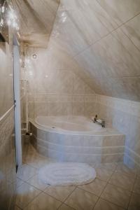 ein Bad mit einer Badewanne in einem Zimmer in der Unterkunft RUDAWSKI in Janowice Wielkie