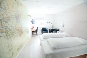 two beds in a room with a map on the wall at Mefjord Brygge in Mefjordvær