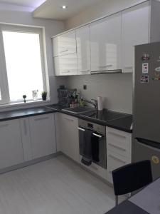 a kitchen with white cabinets and black counter tops at Апартамент за гости Рамона Севлиево 2-спални apartment two bedrooms Sevlievo in Sevlievo