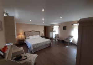 ein Schlafzimmer mit einem Bett und Stühlen in einem Zimmer in der Unterkunft Manoir Des Douets Fleuris in Cancale
