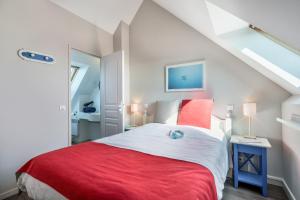 sypialnia z czerwono-białym łóżkiem na poddaszu w obiekcie Résidence Pierre & Vacances Cap Marine w mieście Guilvinec