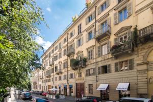 a large building on a street with cars parked in front at Piazza Vittorio Veneto Elegant Flat in Turin