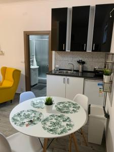 eine Küche mit einem weißen Tisch und Stühlen in der Unterkunft Apartman Hana in Sombor