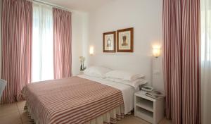 una camera con un letto con una coperta a righe di Hotel Plaza Esplanade a Lido di Jesolo