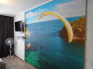 een schilderij van een paraglider over de oceaan bij Apartment WAVE,в центре! in Chmelnytsky