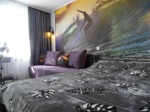 een slaapkamer met een groot schilderij van een surfer bij Apartment WAVE,в центре! in Chmelnytsky