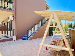 Una escalera de madera frente a una casa con escalera en Villa Plastiras Sidari with private pool en Sidari
