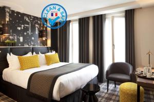 una camera d'albergo con un grande letto e una sedia di Le Grey Hotel a Parigi
