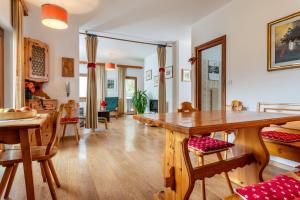 salon z dużym drewnianym stołem i krzesłami w obiekcie Residence Weiss w mieście Vigo di Fassa