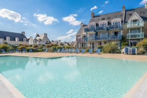 une grande piscine devant un bâtiment dans l'établissement Résidence Pierre & Vacances Cap Marine, au Guilvinec