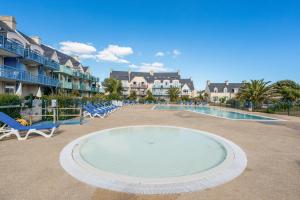 une piscine dans un complexe hôtelier avec des chaises et une piscine dans l'établissement Résidence Pierre & Vacances Cap Marine, au Guilvinec 76 autres photos