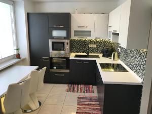 a kitchen with black and white cabinets and appliances at Apartmán v úplnom centre in Vranov nad Topľou
