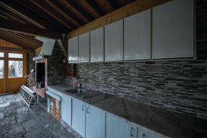 una cucina con lavandino e muro di mattoni di Sete Cidades House a Sete Cidades