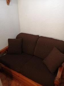 a brown couch in a corner of a room at Le Conifere Garden Residence in Filettino