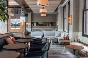 a lobby with tables and couches and a bar at Kimpton Gray Hotel Chicago by IHG in Chicago