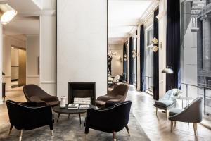 a living room with chairs and a table and a fireplace at Kimpton Gray Hotel Chicago, an IHG Hotel in Chicago