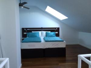 a bedroom with a bed with blue pillows at Felix Saenz by Luma in Málaga