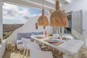 a dining room with a table and chairs at VLIA MAR Myconian Residences in Kalafatis