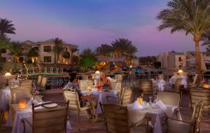 twee mensen die 's avonds aan tafel zitten in een restaurant bij Island View Resort in Sharm El Sheikh