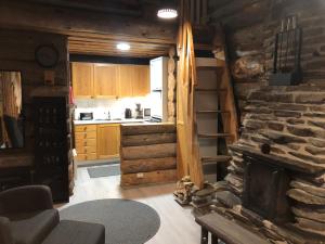 a kitchen with a stone fireplace in a log cabin at Rukansalmi in Ruka