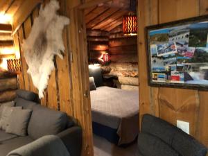 a bedroom in a log cabin with a bed and a couch at Rukansalmi in Ruka