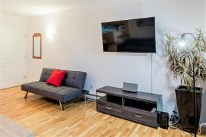 a living room with a couch and a tv at Le Théâtral - En plein coeur de l'action avec stationnement in Quebec City