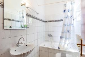 a white bathroom with a sink and a tub at San Giorgio Villa in Kalabaka