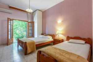 a bedroom with two beds and a window at San Giorgio Villa in Kalabaka