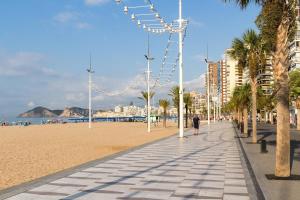 una persona caminando por una playa con palmeras en Apartamento Santonja a 300 metros de la playa, en Benidorm