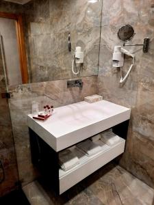a bathroom with a white sink and a shower at BejaParque Hotel in Beja