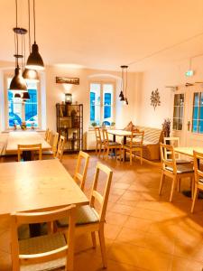 un ristorante con tavoli e sedie in legno e finestre di Penzion Laterna a Litoměřice Altre 18 foto