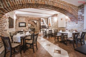 comedor con paredes de ladrillo, mesas y sillas en Hotel Varazdin en Varaždin