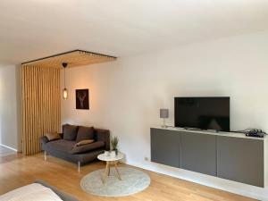 a living room with a couch and a tv at Ferienwohnung am Ententeich in Bad Marienberg